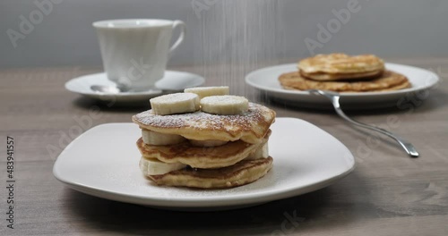 Il cuoco mette lo zucchero a velo sul pancake photo