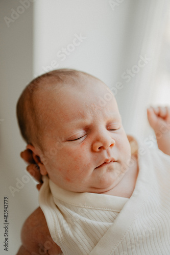 Little newborn girl in her mother's arms. Close-up photo.