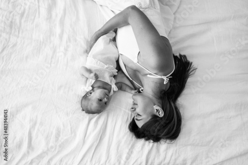 A young mother with a newborn daughter on the couch. photo