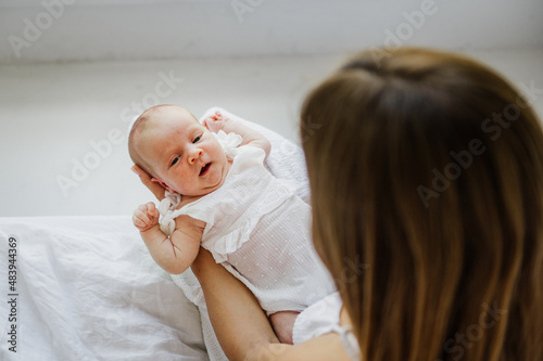 Little newborn girl in her mother's arms. Close-up photo.