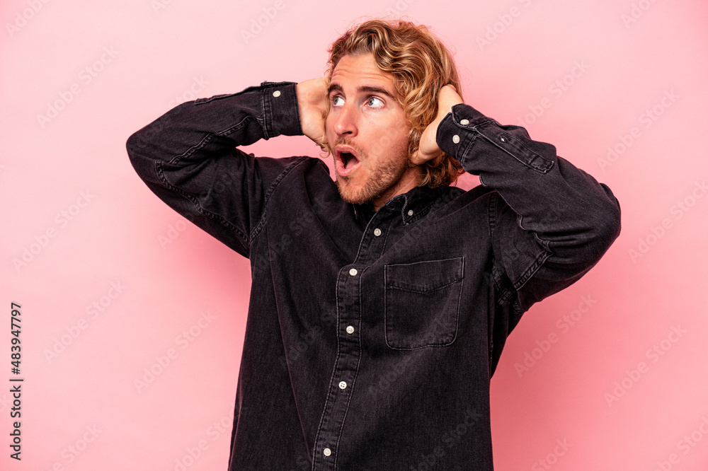 Young caucasian man isolated on pink background screaming, very excited, passionate, satisfied with something. Young caucasian man isolated on pink background screaming, very excited, passionate, satisfied with something.
