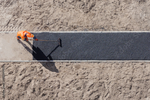 Papier peint Laying worker new asphalt paving road construction site work pathway