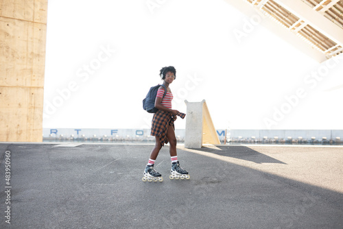 Fototapeta Naklejka Na Ścianę i Meble -  Beautiful African woman with roller skates. Urban sexy girl enjoy outdoors.