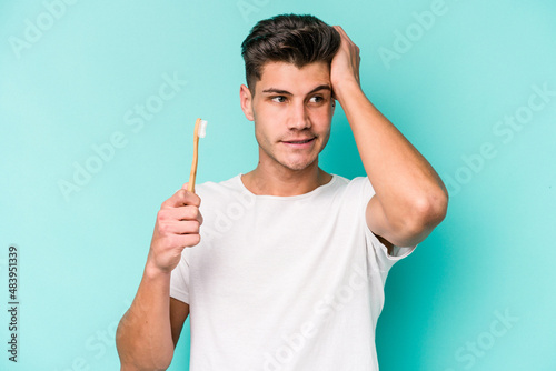 Young caucasian man brushing teeth isolated on white background being shocked, she has remembered important meeting.