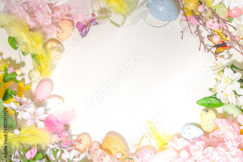 Easter holiday top view flat lay frame background with easter colorful eggs  and spring flowers. Spring holiday greeting card background  copy space