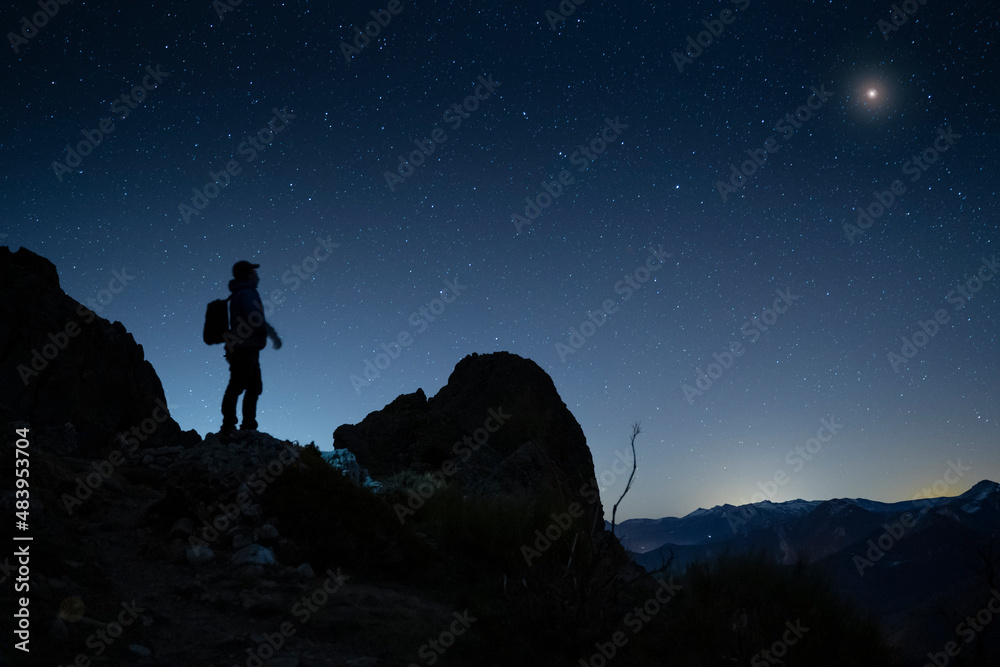 hiker looking to the night sky in the mountains hiker looking to the night sky in the mountains