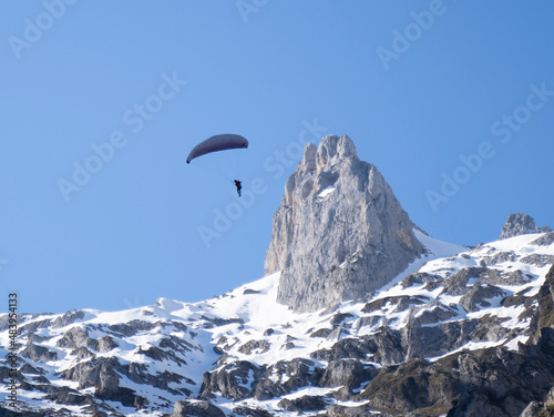Foto parachuter flying with  his parachute over snowy mountains