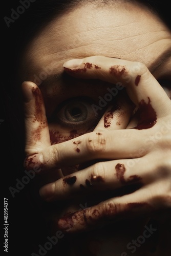 Woman covering her face in fear closeup photo
