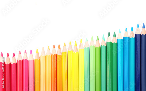 Colored pencils lined up on white paper background. Copy space. Back to school. Office supplies.