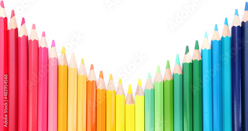Colored pencils lined up on white paper background. Copy space. Back to school. Office supplies.