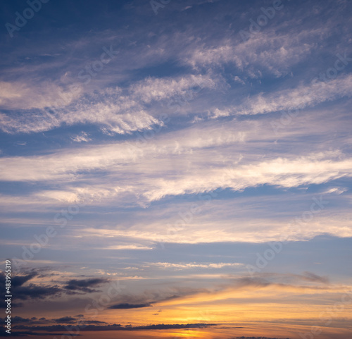 Picturesque evening sky with streaks of white cirrus clouds and sunlight. Sky replacement texture.