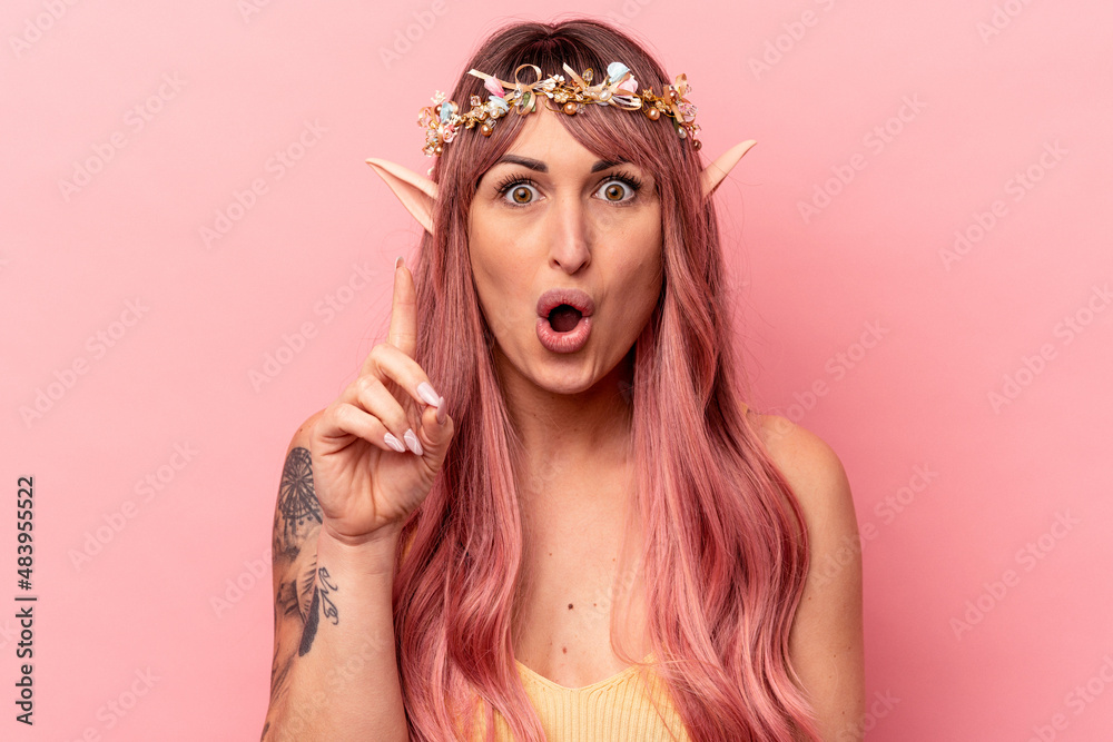 Young caucasian elf woman isolated on pink background having some great idea, concept of creativity.