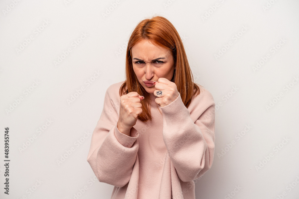 Young caucasian woman isolated on white background showing fist to camera, aggressive facial expression. Young caucasian woman isolated on white background showing fist to camera, aggressive facial expression.