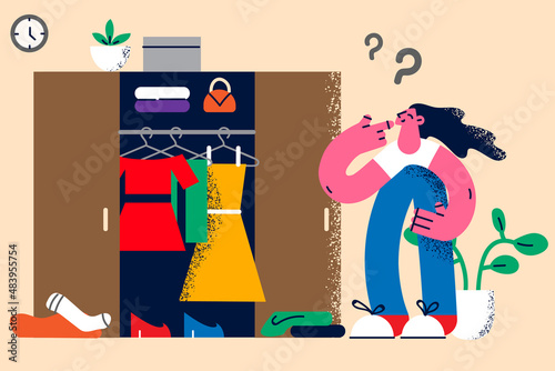 Pensive woman look in wardrobe thinking about clothes 