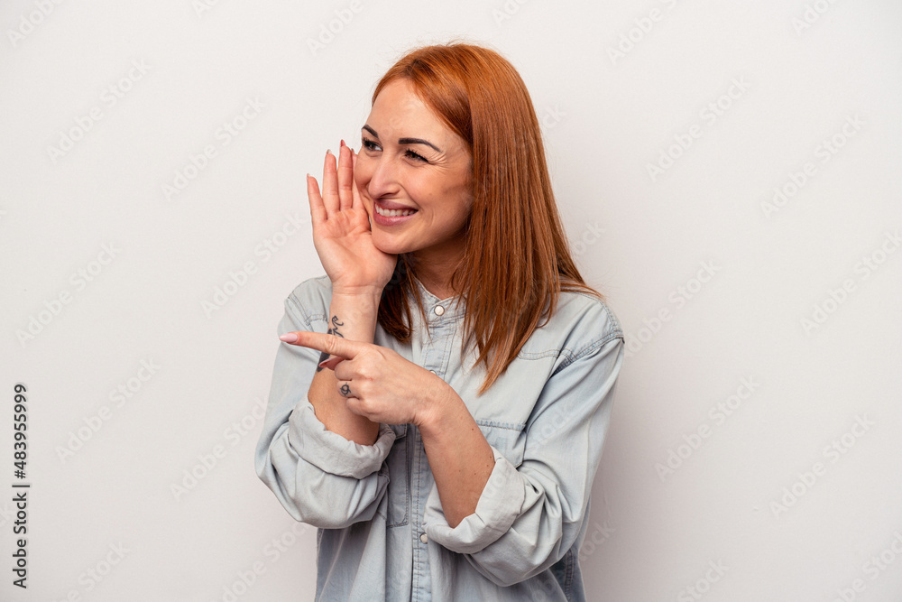 Young caucasian woman isolated on white background saying a gossip, pointing to side reporting something. Young caucasian woman isolated on white background saying a gossip, pointing to side reporting something.
