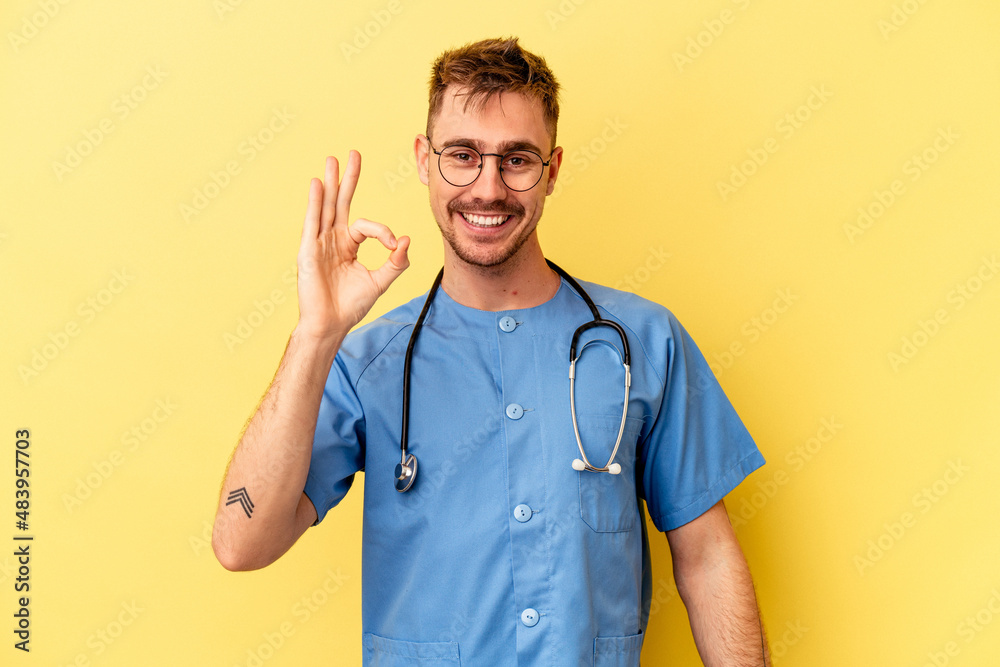 Young nurse caucasian man isolated on yellow background cheerful and confident showing ok gesture. Young nurse caucasian man isolated on yellow background cheerful and confident showing ok gesture.