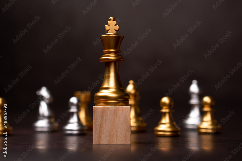 Golden king chess standing on a wooden stand. The concept of Leaders in good organizations must have a vision and can predict business trends and assess competitors Golden king chess standing on a wooden stand. The concept of Leaders in good organizations must have a vision and can predict business trends and assess competitors