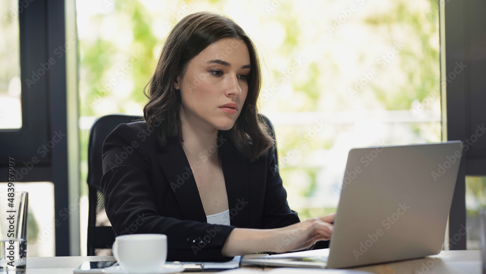 concentrated businesswoman typing on laptop at workplace concentrated businesswoman typing on laptop at workplace