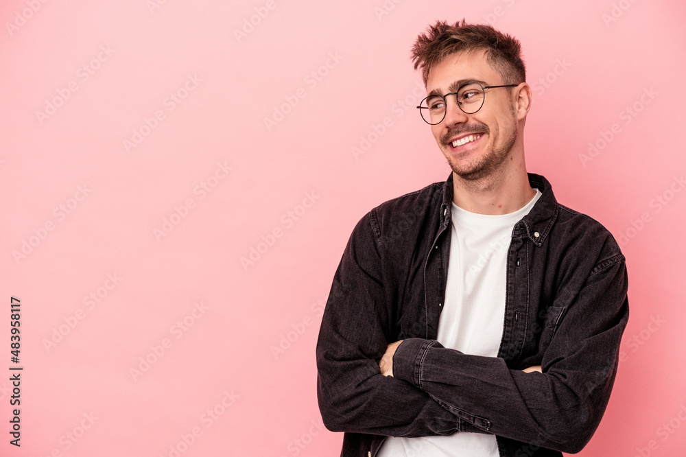 Young caucasian man isolated on pink background smiling confident with crossed arms. Young caucasian man isolated on pink background smiling confident with crossed arms.