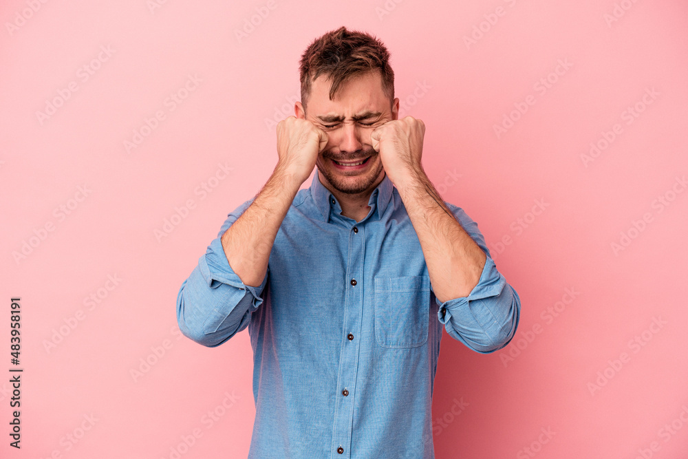 Young caucasian man isolated on pink background whining and crying disconsolately. Young caucasian man isolated on pink background whining and crying disconsolately.
