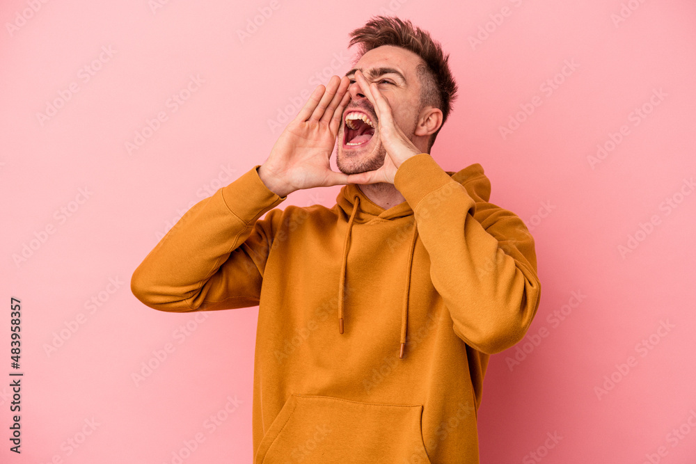 Young caucasian man isolated on pink background shouting excited to front. Young caucasian man isolated on pink background shouting excited to front.