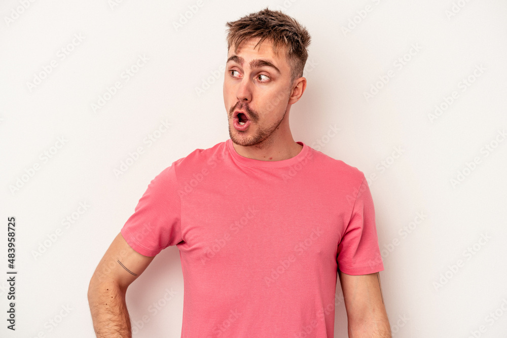 Obraz premium Young caucasian man isolated on white background showing rock gesture with fingers