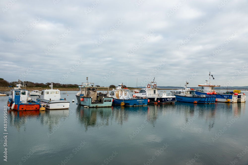 row of colourful fishing boats in the water at Keyhaven  England on a winters day