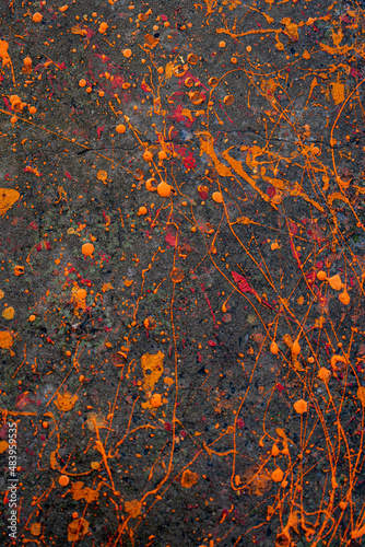 Splashes of orange and red paint on a cement at the contruction site. Abstract background