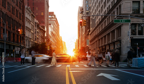 Canvas Print Sunlight shining on the people and cars at a busy intersection on 5th Avenue in
