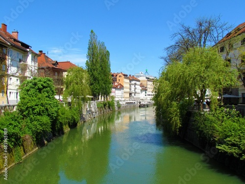 Ljubljanica river flowing through Ljubljana city in Slovenia and the Franciscan Church of the Annunciation and a reflection of the buildings in the river