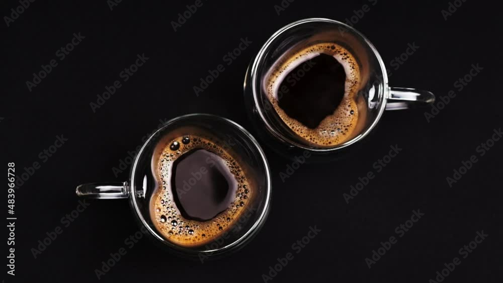 Heart sign made from coffee cups on a textured dark background. Valentine's day concept and coffee or caffeine addiction or health benefits. coffee traditions. High-quality shooting in 4k format