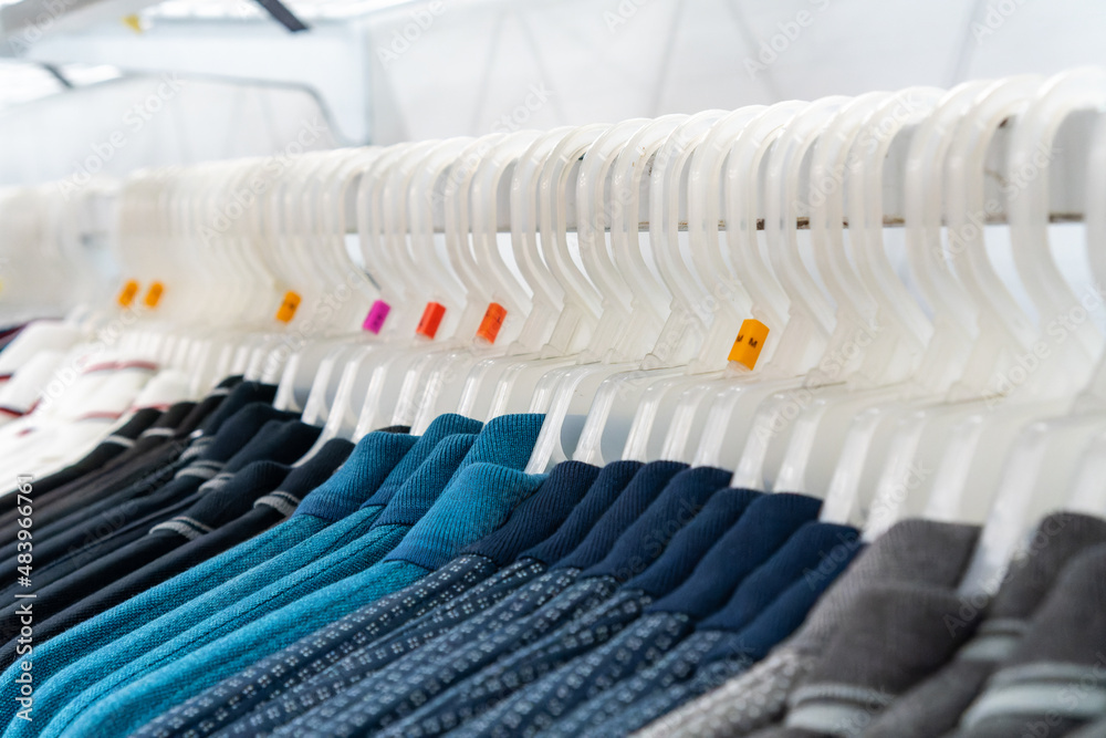 Clothes of various sizes hanging in the shop window