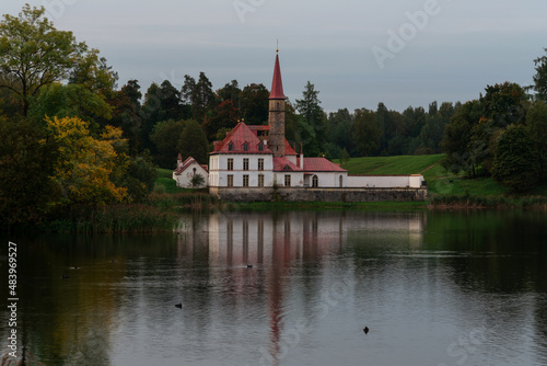 View of the Priory Palace on the shore of the Black Lake on an autumn sunny evening with clouds, Gatchina, St. Petersburg, Russia