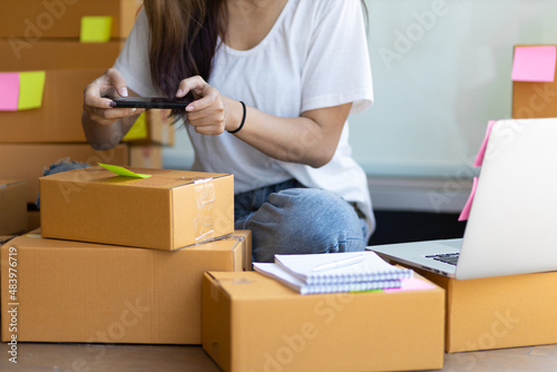 An online business courier taking pictures of parcels for customers. © Wasan