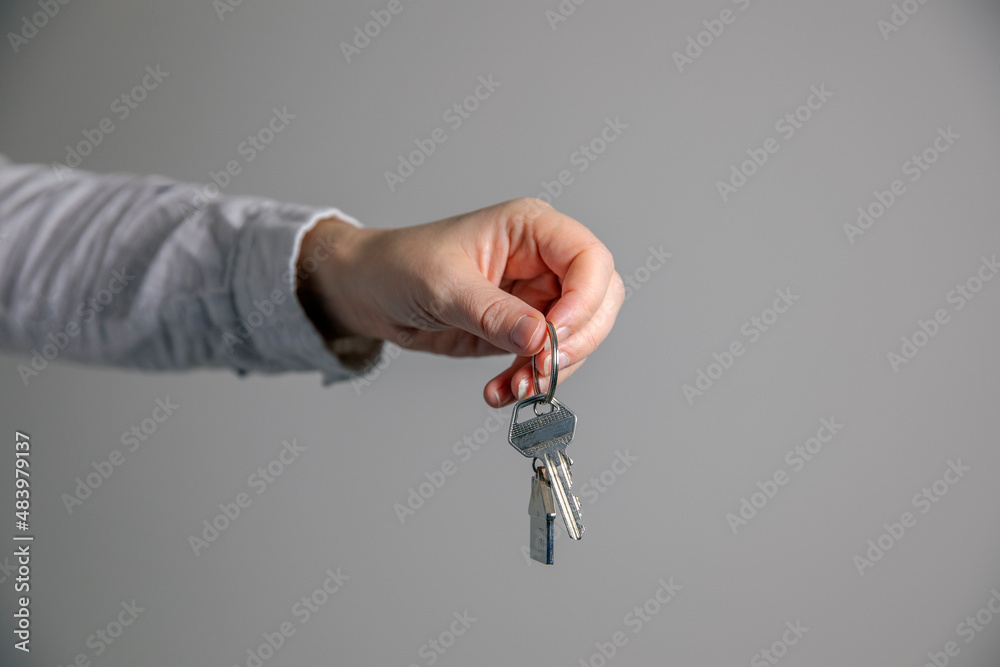 Real estate agent with house model and keys, selling house,property owner mortgage concept with copy space on gray background Real estate agent with house model and keys, selling house,property owner mortgage concept with copy space on gray background