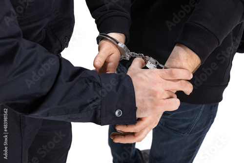 Close-up male hands in handcuffs. Policeman officer arrests a criminal isolated on white background. Concept of job, caree, safety. Security service.