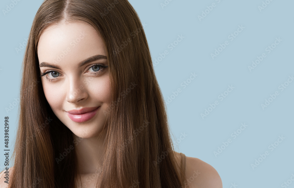 Fototapeta premium Woman with long smooth hair beautiful face happy. Color background. Blue