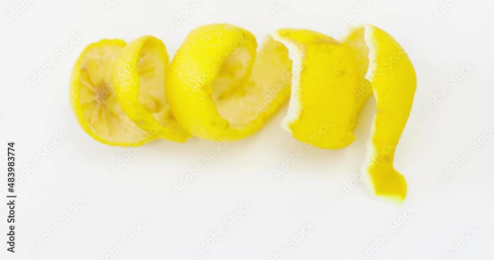Slow moving onto the lemon rind which is twisted in a spiral isolated on white background Slow moving onto the lemon rind which is twisted in a spiral isolated on white background