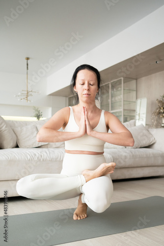 Pregnant woman doing prenatal yoga at home in the living room. Fitness for pregnant women.