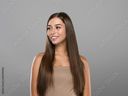 Beautiful freckles woman healthy hair long smooth brunette hairstyle Color background Gray