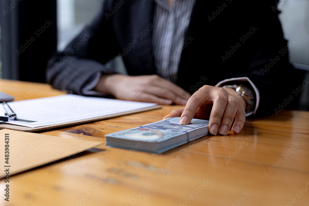 Businessmen are getting a lot of dollars from their business partners as money for bribery, bribery is an illegal act, corruption concept. Panorama banner background with copy space. Businessmen are getting a lot of dollars from their business partners as money for bribery, bribery is an illegal act, corruption concept. Panorama banner background with copy space.