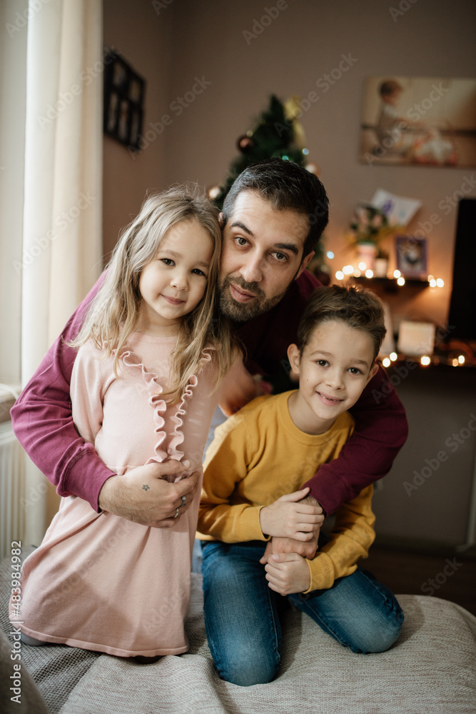 Father and children looking at camera.