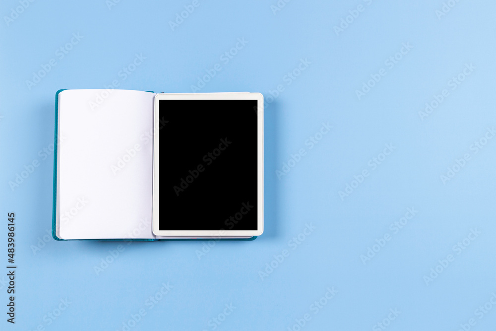 Top view to open book with digital tablet computer screen on blue background. Modern remote education, e-learning, remote learning, online work, planning, freelance, start business Top view to open book with digital tablet computer screen on blue background. Modern remote education, e-learning, remote learning, online work, planning, freelance, start business