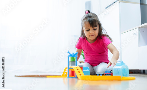 baby game. Little clever caucasian child playing colorful toy railway and train for early development.