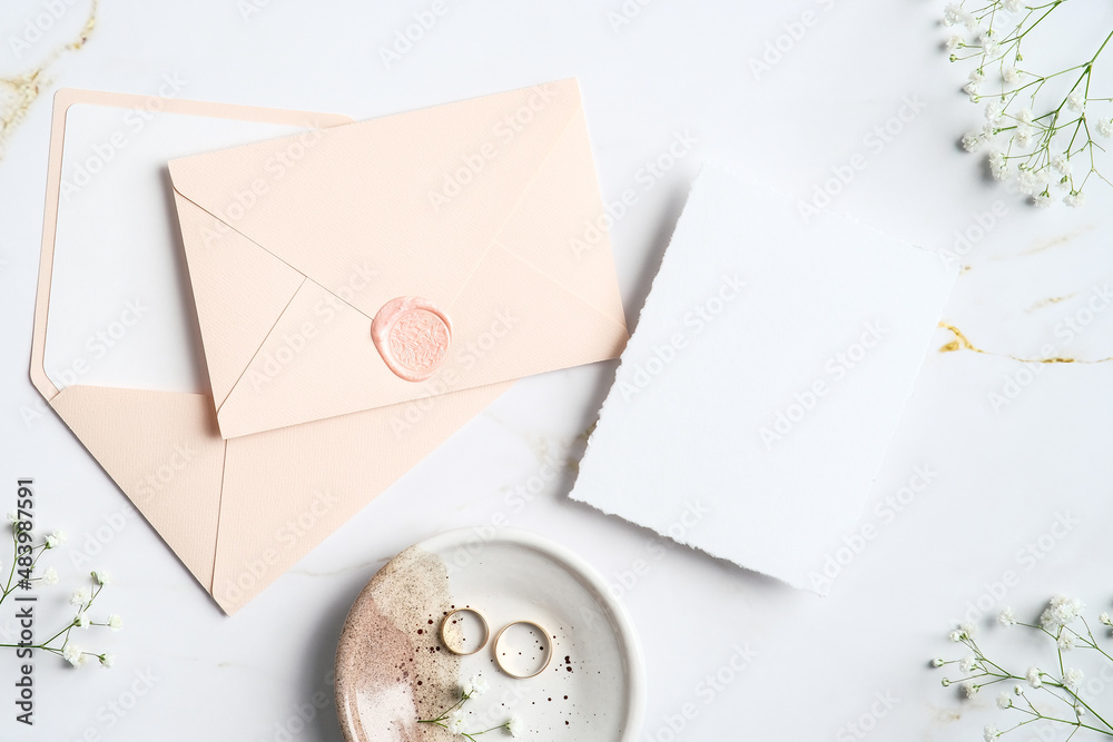 Wedding stationery top view. Flat lay pastel pink envelopes, wedding invitation card, rings, flowers on marble table. Wedding stationery top view. Flat lay pastel pink envelopes, wedding invitation card, rings, flowers on marble table.