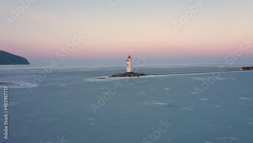 The sea lighthouse on the stone spit Tokarevskaya Koshka, in winter, Vladivostok, Russia. Top view photo