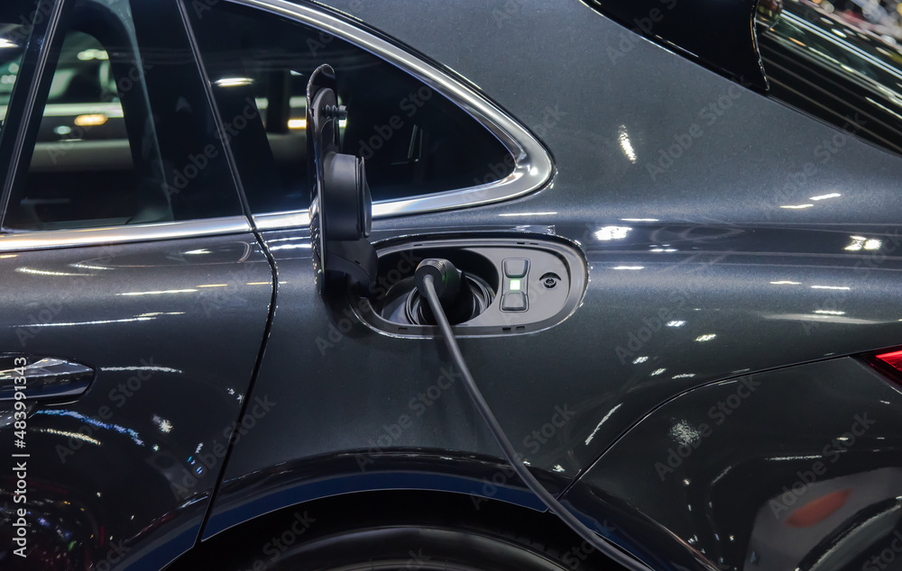 Fototapeta premium Electric car charging plug in the city.