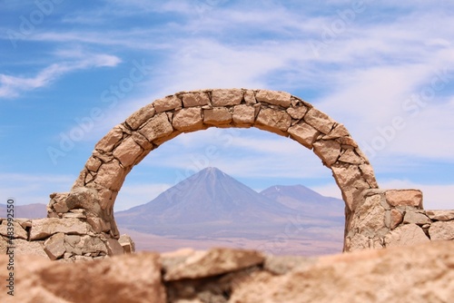 Stone arch at Pukara de Quitor - fortress at Atacama desert and Licancabur volcano on the background, Chile. photo