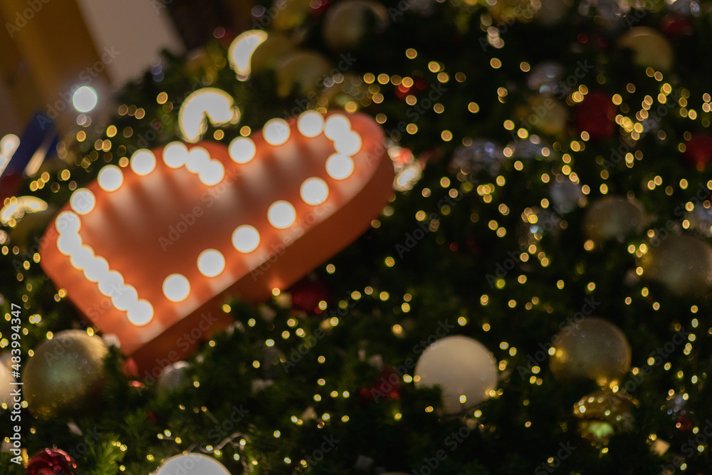 Blurred background, heart-shaped bokeh lights on the Christmas tree are beautifully decorated and the heart symbol signifies love, friendship and kindness. heart shaped lights abstract background Blurred background, heart-shaped bokeh lights on the Christmas tree are beautifully decorated and the heart symbol signifies love, friendship and kindness. heart shaped lights abstract background
