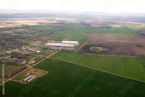 Aerial landscape view of green cultivated agricultural fields with growing crops on bright summer day